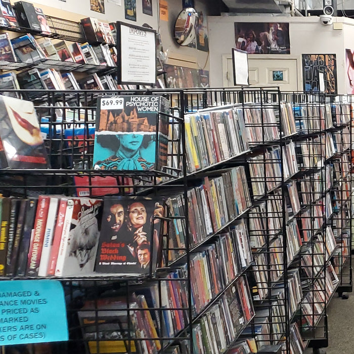 Interior of a DVD store with rows of shelves stocked with movies.